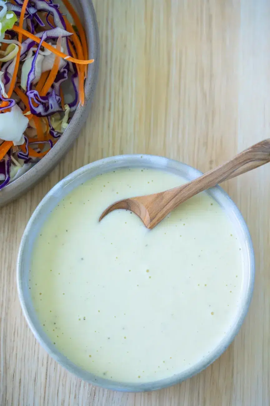 coleslaw dressing in bowl with spoon