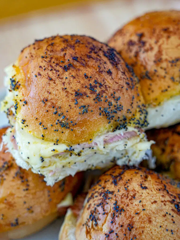 Close-up of baked ham and cheese sliders with a golden-brown top
