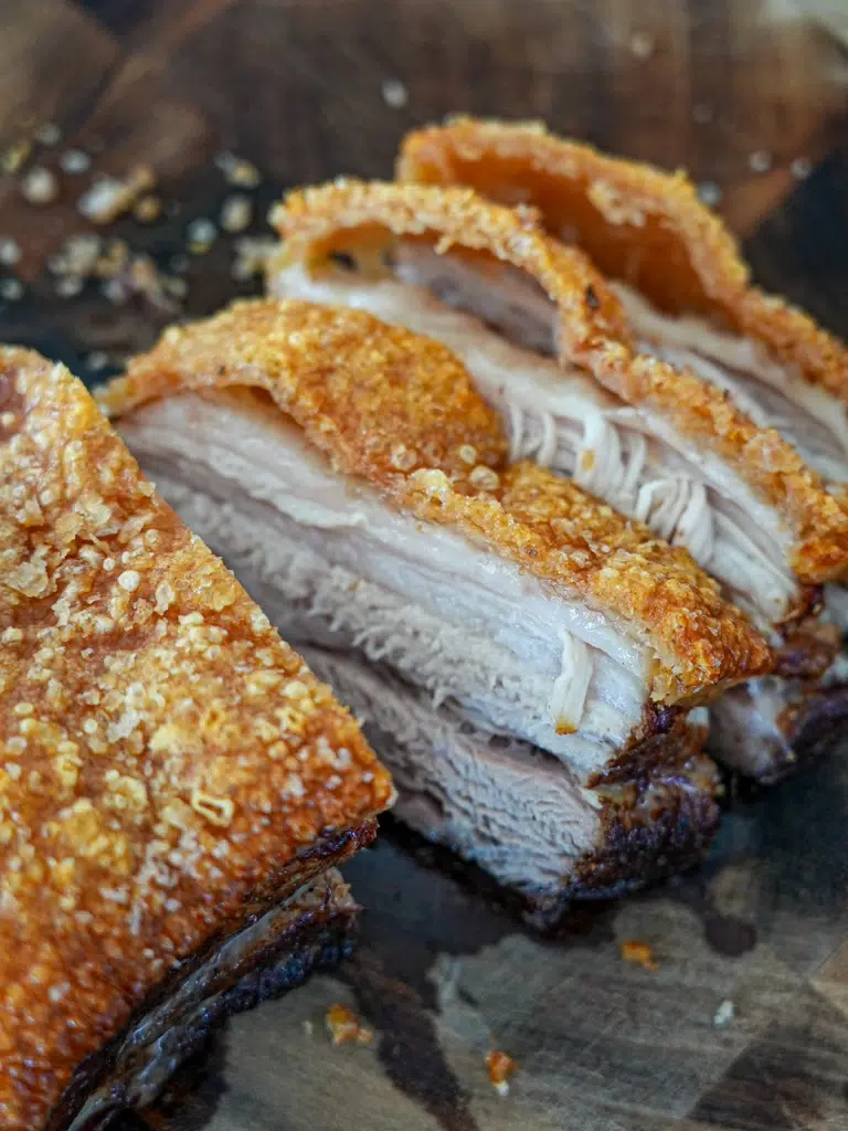 Freshly sliced pork on a cutting board.