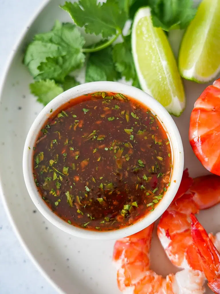 Tray of freshly cooked prawns served with a bowl of Sweet Chilli Lime Sauce, ready to enjoy.
