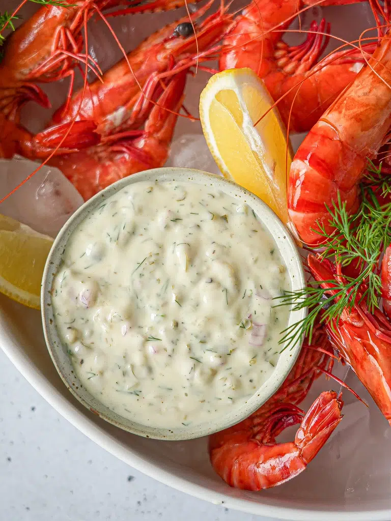 Tray of prawns served with a bowl of tartare sauce, ready for dipping.