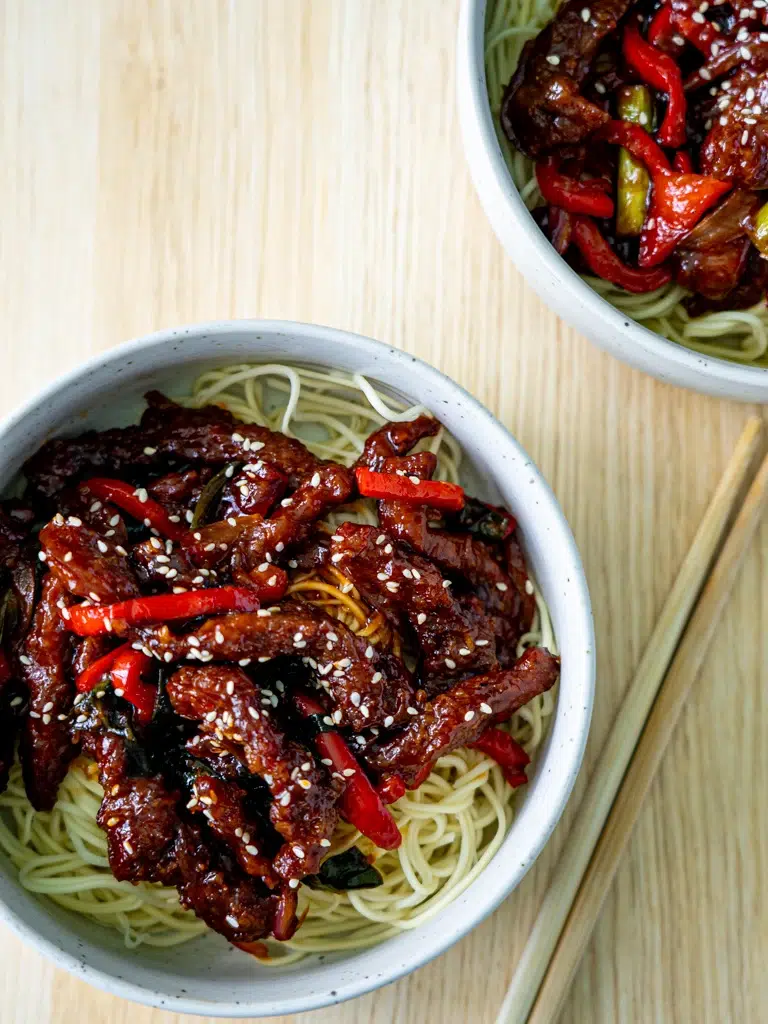 Top view of two servings of Sticky Rainbow Beef in bowls.