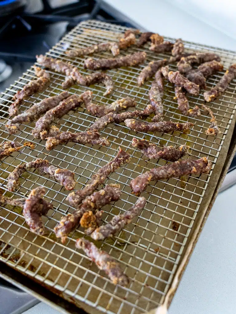Baked beef resting on a wire rack.