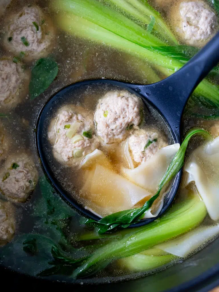 Overhead shot of a pot filled with deconstructed wonton soup ingredients.