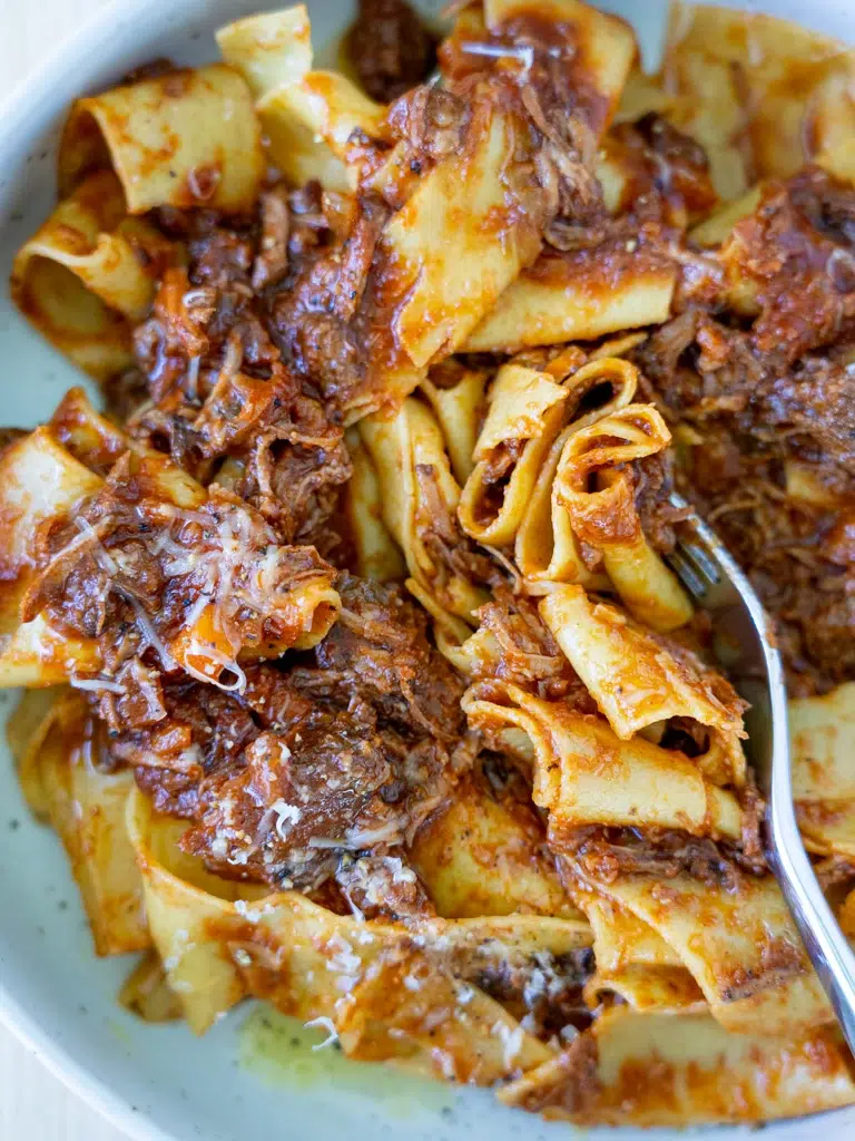 Hearty slow cooker beef ragu with a fork digging in.