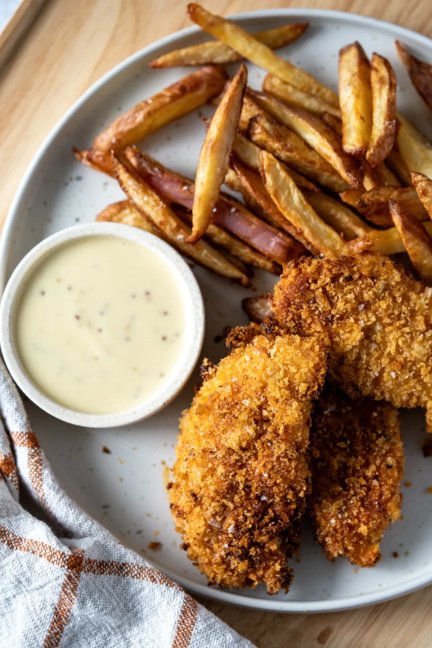 Final plated dish of crispy chicken served with honey mustard dipping sauce, overhead view for a homemade fakeaway-style meal.