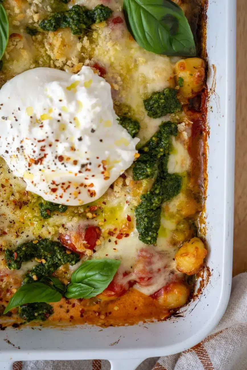 Close-up in tray showing baked golden gnocchi and stretchy cheese